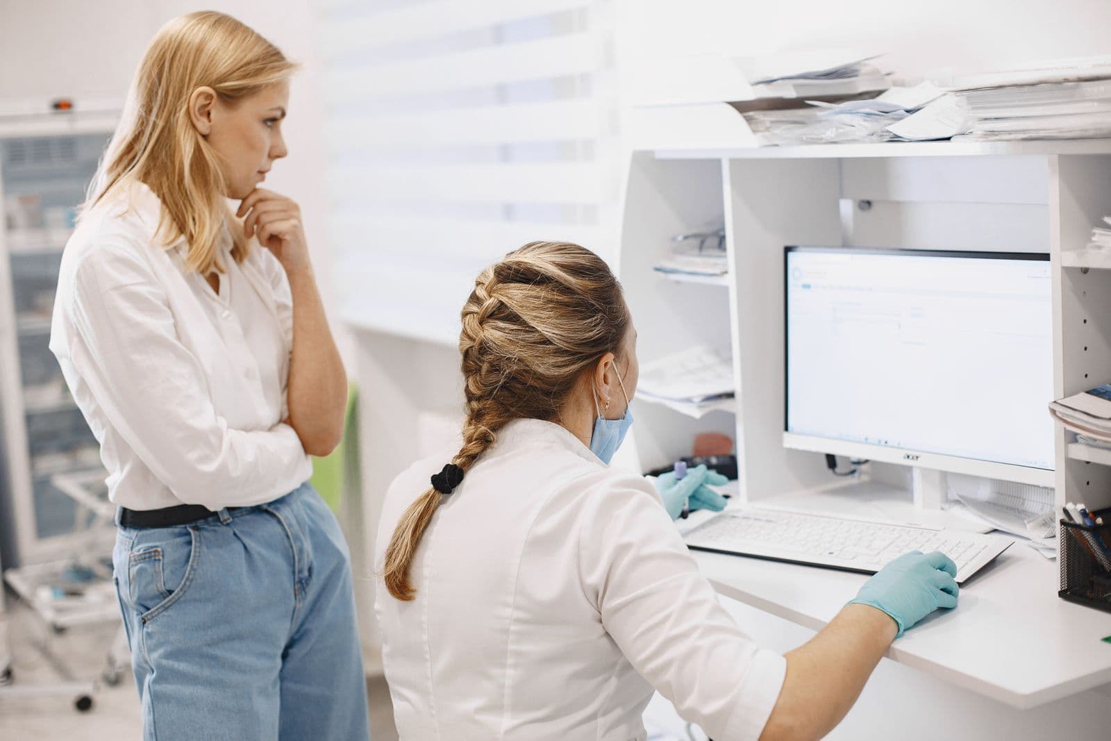 Profissionais de saúde a consultar um computador numa clínica